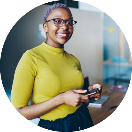 Smiling young African American woman holding smartphone